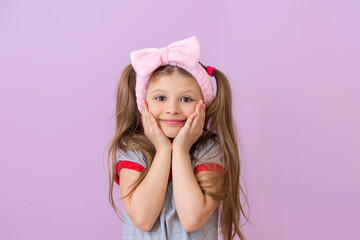 The little girl is very happy and holds her hands near her cheeks.