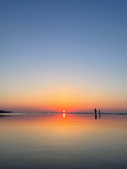 silhouette of two people on the beach