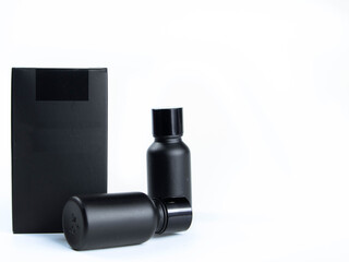 Glass bottle of hair care cream mixed with small black bamboo charcoal powder, placed on a white background. With a black packing box