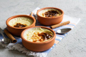 Baked rice pudding turkish milky dessert sutlac in casserole with cinnamon sticks and hazelnuts