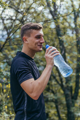Male athlete drinking water, refreshing, hydrating after a long exhausting workout, run.