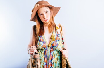 Beautiful young woman in beach hat sundress with bags puffing. concept problems in summer vacation