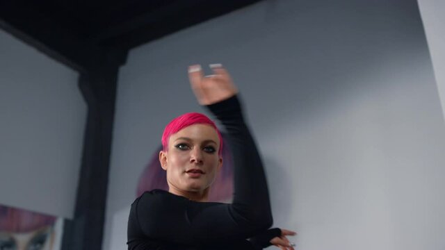 Graceful woman dancing in class. Fitness model posing for camera in studio.