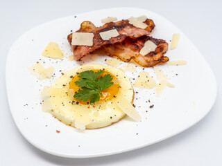 breakfast with fried egg and bacon on white plate