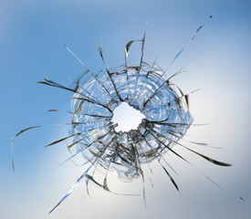 Cracks in the window glass on a background of sky.