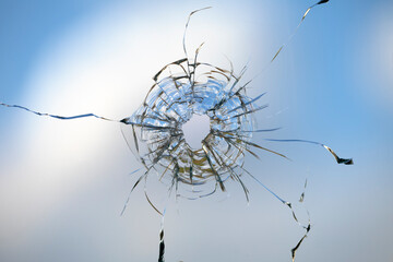 Cracks in the window glass on a background of sky.