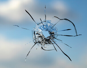 Cracks in the window glass on a background of sky.
