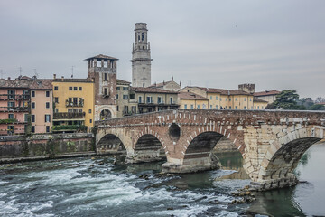 Obraz premium View of Stone Bridge (Ponte Pietra or Pons Marmoreus) - Roman arch bridge crossing the Adige River in Verona, Italy. The bridge completed in 100 BC, is the oldest bridge in Verona.