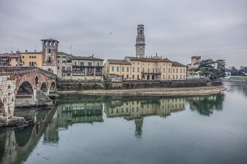 Fototapeta na wymiar View of Stone Bridge (Ponte Pietra or Pons Marmoreus) - Roman arch bridge crossing the Adige River in Verona, Italy. The bridge completed in 100 BC, is the oldest bridge in Verona.