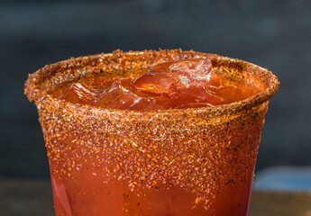 close up of iced clamato drink with salt and hot chili