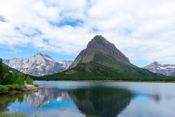 Naklejka na ściany i meble Mountain landscape reflected in water on a summer day at Glacier National Park