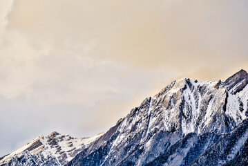 The snow topped Three Sisters and mountains surrounding Canmore Alberta at sunset