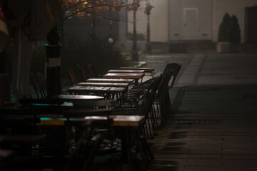 Fototapeta na wymiar Selective blur on an Empty terrace and patio of a bar restaurant of Belgrade, Serbia in an evening night, closed due to the coronavirus covid 19 lockdown measures to prevent the spread of the disease