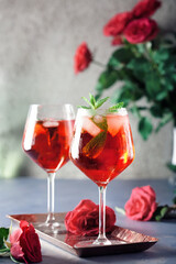 Two alcohol cocktails set with red roses