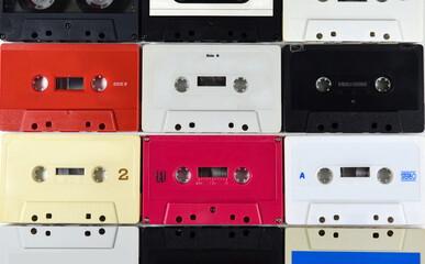 Vintage wall of colored cassette tapes as background.