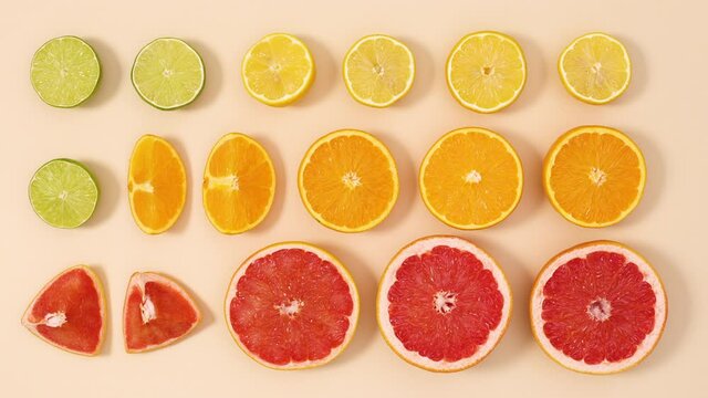 Creative layout made of fresh organic sliced citrus fruits on sandy background. Stop motion flat lay