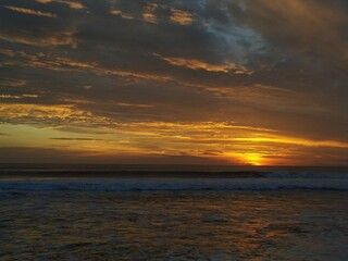 Obraz na płótnie Canvas Beautiful cloudy sunset at Kuta beach, Bali, Indonesia. Kuta is the famous beach in Bali island. 