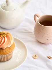 Pretty pink cupcake and pink bug with white teapot on a white background
