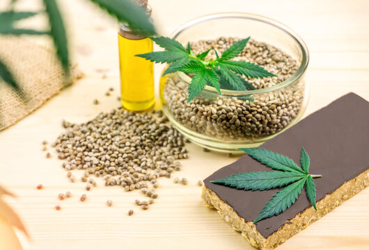 Cannabis seeds in bowl oil and hemp seed cereal bar with chocolate
