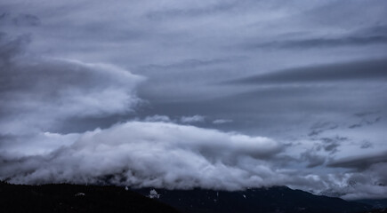 View of Puffy Clouds over the Canadian Mountain Landscape. Colorful Winter Sunset Cloudscape Background. Taken between Squamish and Whistler, British Columbia, Canada.