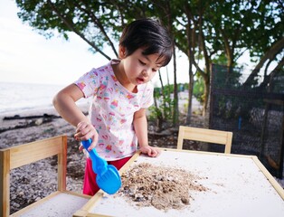 girl are playing in the sand on a table against the backdrop of the beach
