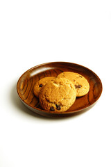 oatmeal cookies with chocolate are placed on a beautiful wooden plate. cookies with crumbs.