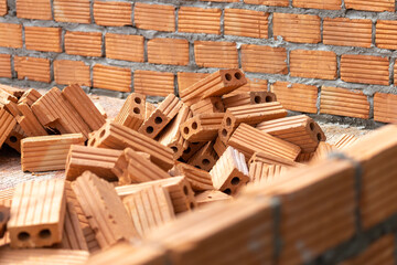 Obraz na płótnie Canvas A large pile of orange bricks is prepared for the construction of the walls of the building.