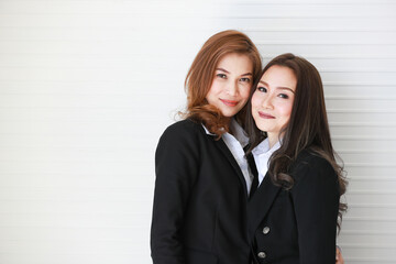 Confident Asian businesswomen against gray wall