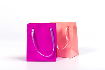 two colourful paper shopping bags isolated on white background, mockup for design
