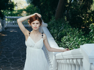 Fototapeta na wymiar Pretty woman in white dress outdoors green leaves walk model