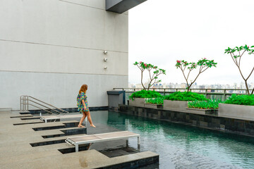 Young woman enjoying the pool with a view of the skyscrapers in São Paulo city center. Some of the...