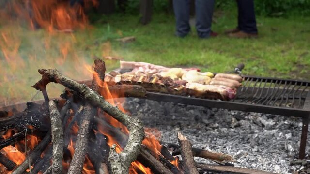 Fuego con carne asada a las brasas. Asado tradicional Argentina. Fogata y barbacoa a la parrila. Slow Motion. En c&aacute;mara lenta.