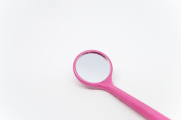 Close-up shot of a mini pink eyelash extension mirror made of plastic on top of a white background.