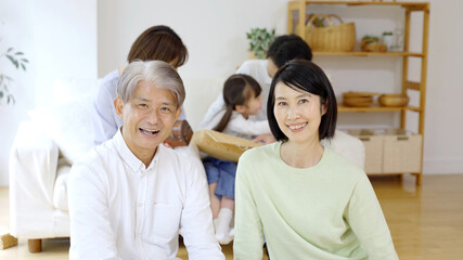 リビングでリラックスする三世代家族