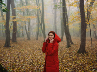 Woman in red jacket in autumn Yellow leaves walk the fog