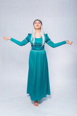 Full length portrait of a princess in a medieval, fantasy, turquoise dress with ash hair and a silver crown, posing isolated on a white background.