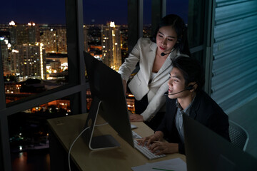 Selective Focus. Female telemarketers operators working late at night in a call center. Technical, Customer service use a headset to answering customer questions. Telemarketing Communication support.
