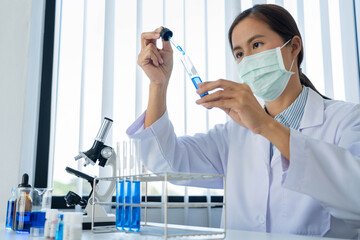 scientists researching in laboratory in white lab coat, gloves analysing, looking at test tubes sample, biotechnology concept