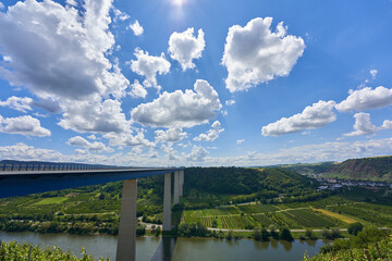 Beautiful Mosel Valley bridge made of blue steel and gray pillars, large trees in the background,...