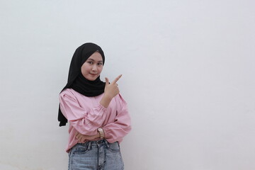 Perfect asian muslim woman looking on camera pointing to copy space. Beautiful asian woman with casual dress. Beautiful muslim women.