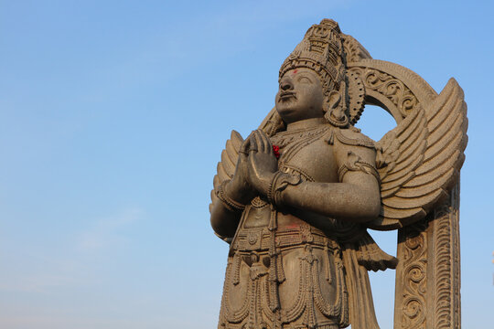 Stone sculpture - Garuda - half-man half-bird, stands with folded in prayer hands and looks up. Garuda is the bearer of Lord Vishnu.