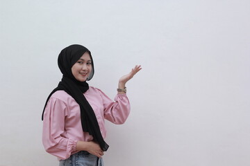 Smiling asian muslim women pointing to copy spcae. Beautiful asian woman with casual dress. Beautiful muslim women.