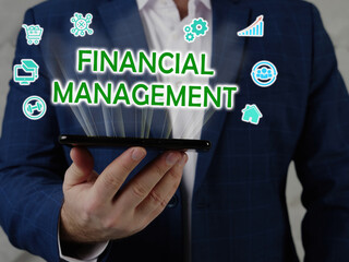  FINANCIAL MANAGEMENT inscription on the screen. Close up Broker hands holding black smart phone.
