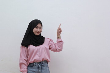 Beatifull asian muslim woman up her finger and smiling on camera. Beautiful asian woman with casual dress. Beautiful muslim women. 