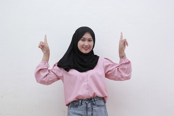 Portrait smiling asian woman looking on camera and pointing to copy space. Beautiful asian woman with casual dress. Beautiful muslim women.