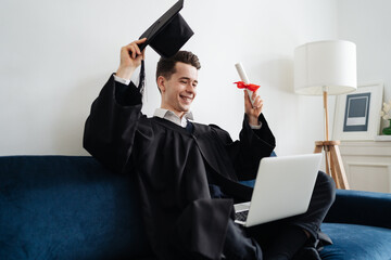 Education, graduation and people concept - happy male student with diploma and laptop at home...