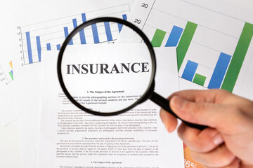 Man looking through a magnifying glass to the Blank insurance claim form.