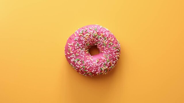 Top view colorful sweet ring donut with pink glaze bright pastry topping. Shot with RED camera in 4K