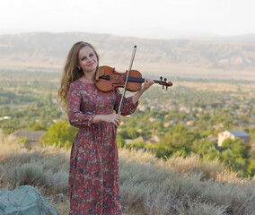woman is playing violin outdoors