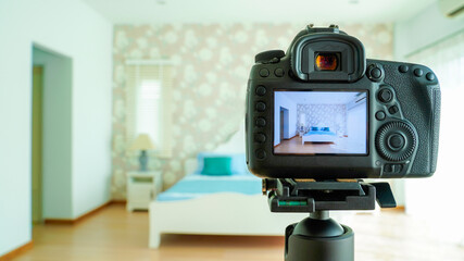 Camera on a tripod in bedroom interior, Professional dslr digital camera, selective focus, Horizontal orientation, copy space.